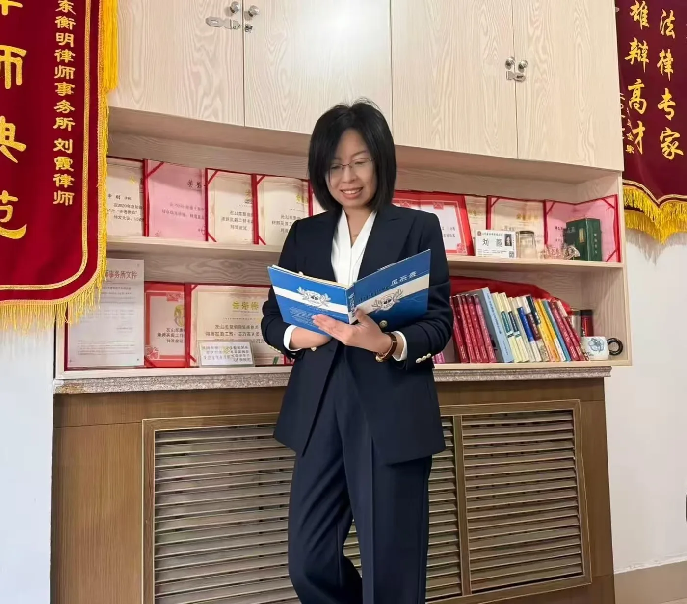 刘霞律师在办公室书架前翻阅案卷